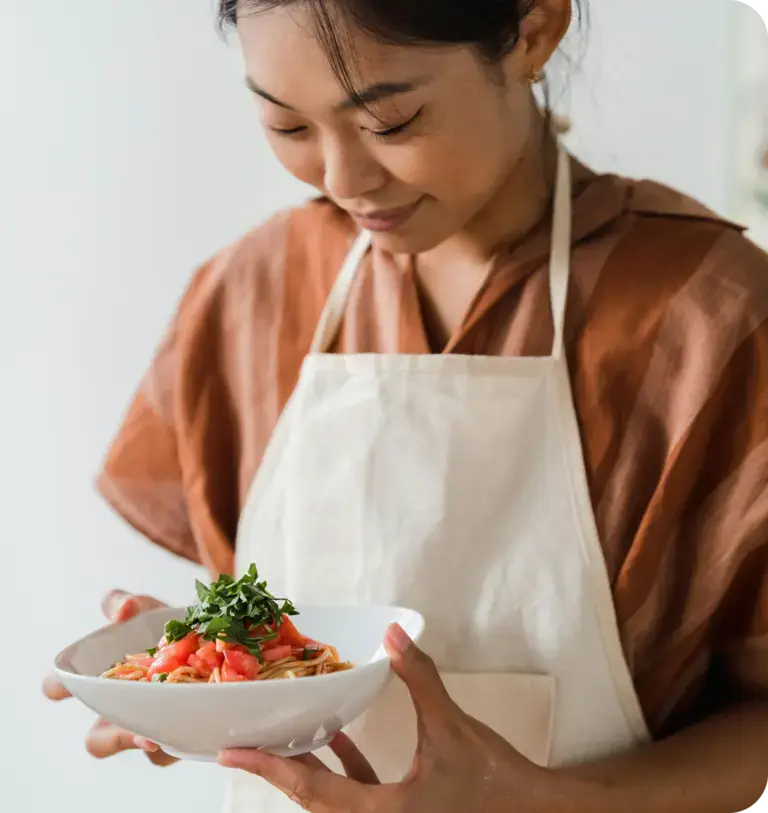 una chef mira un plato de espaguetis