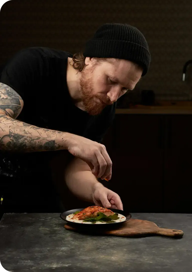 un mesero lleva un primer plato a una comensal