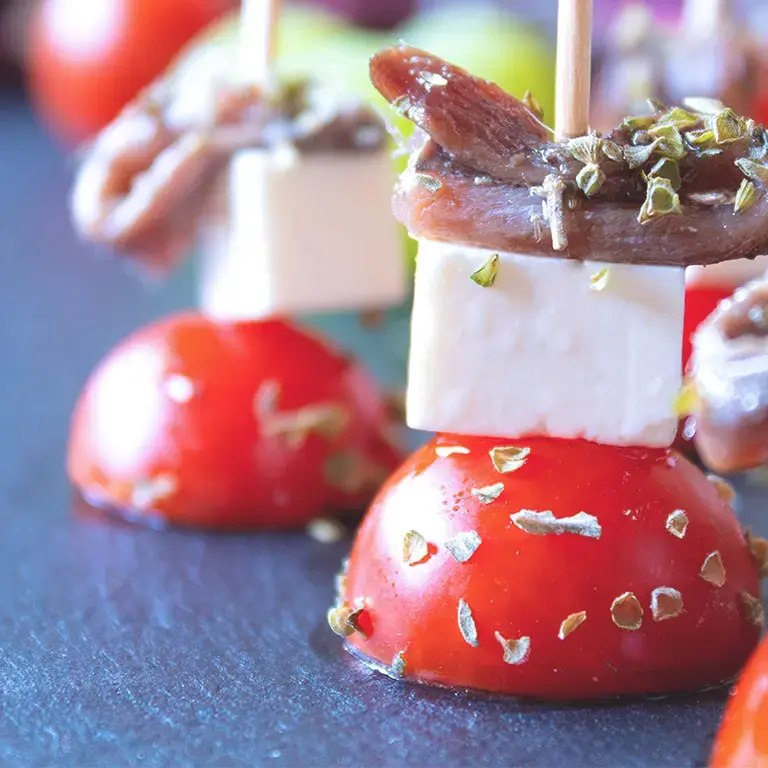 Spiedini di pomodorini con acciughe e formaggi freschi