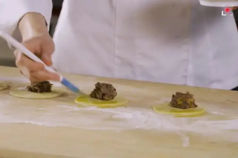Coloca una bola de relleno aplastada en el círculo de masa cortada.
