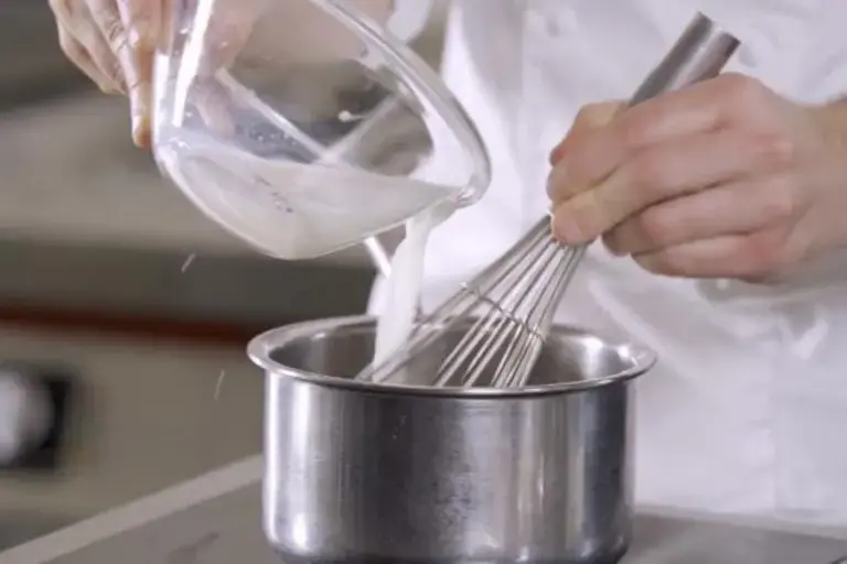 Vertiendo leche en la sartén.