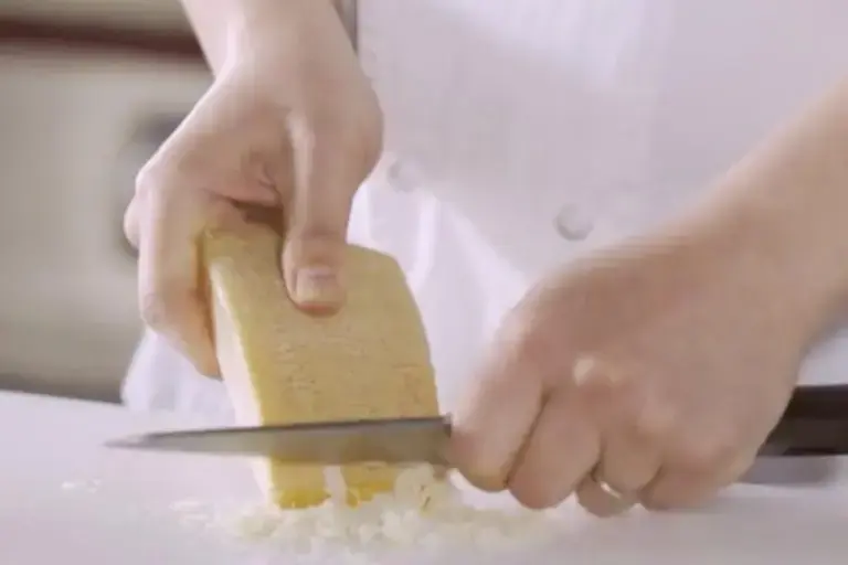 Tome la corteza del parmesano y raspa la capa exterior con un cuchillo.